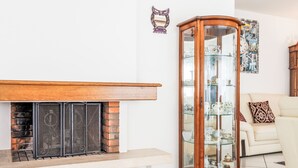 Un salon avec une cheminée, une vitrine et un canapé.