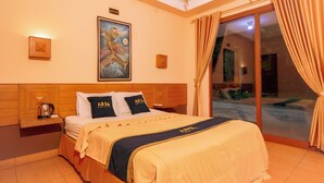 A hotel room with a bed, a nightstand, a painting, and a view of the outside. - Lembah Gunung Kujang by ARBA (Cijambe)