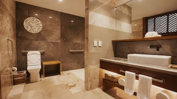 Ein modernes Badezimmer mit Marmorboden, einem weißen Waschbecken und einem hölzernen Waschtisch.