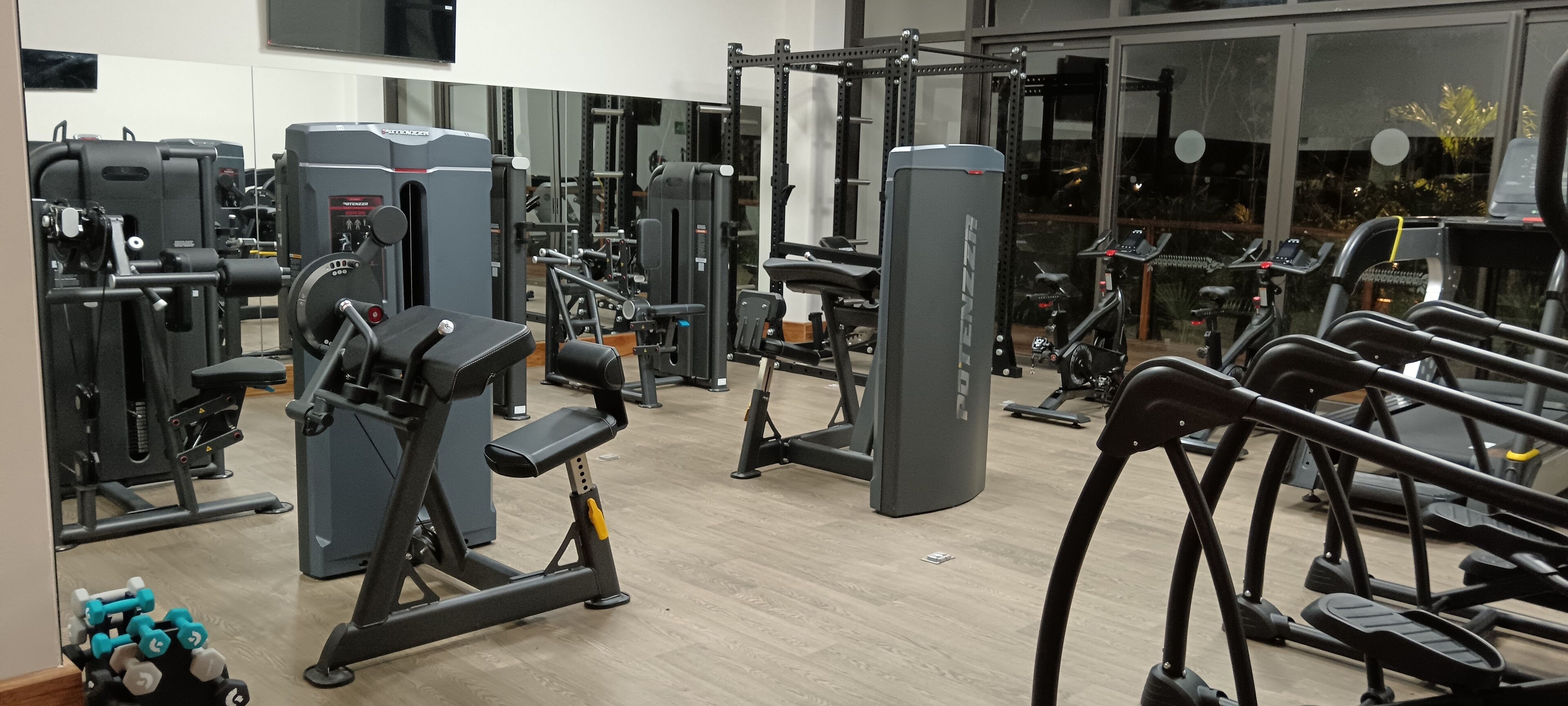 A gym with various exercise equipment, including treadmills, weight machines, and free weights.