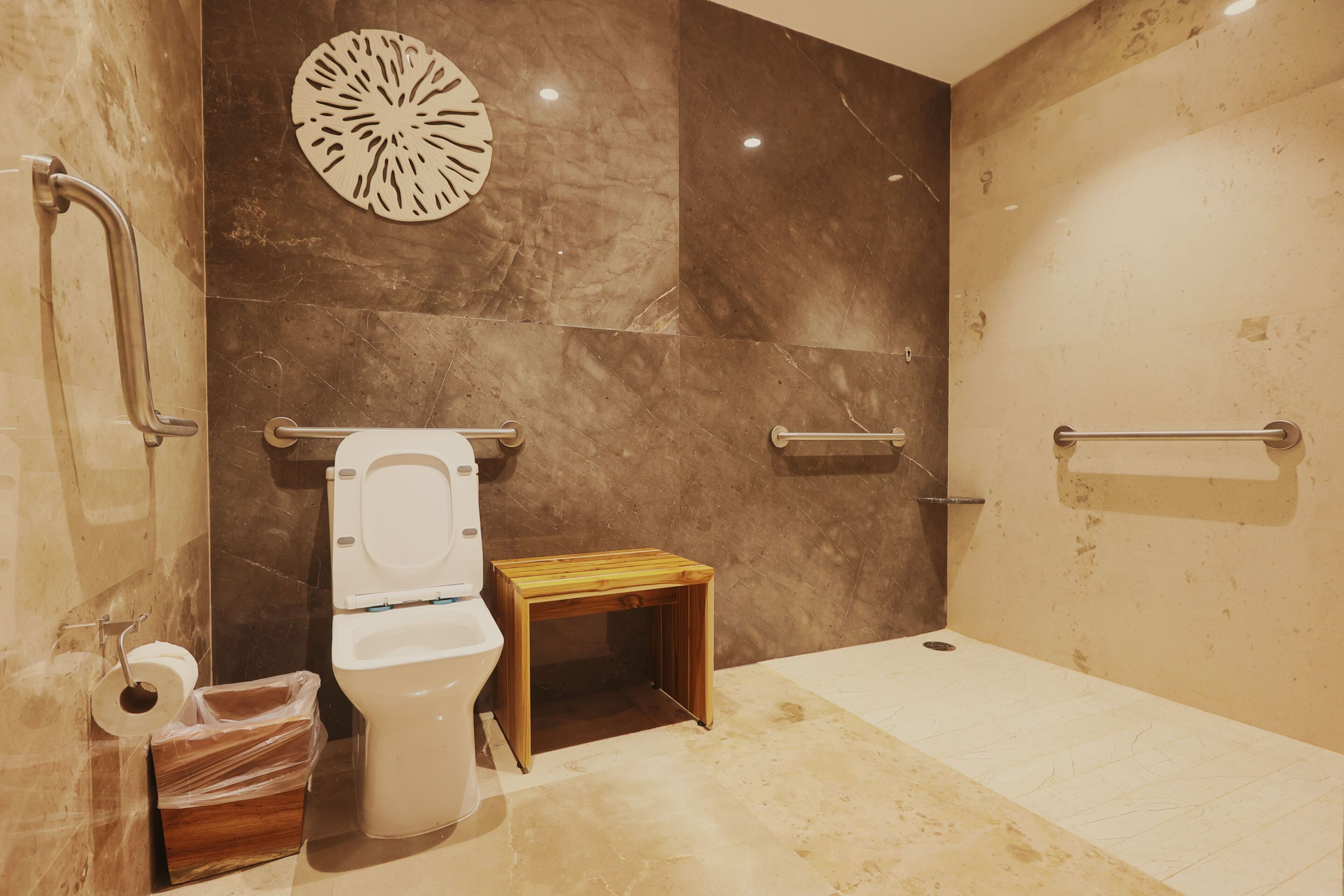 A bathroom with a toilet, a small wooden table, and a shower area.