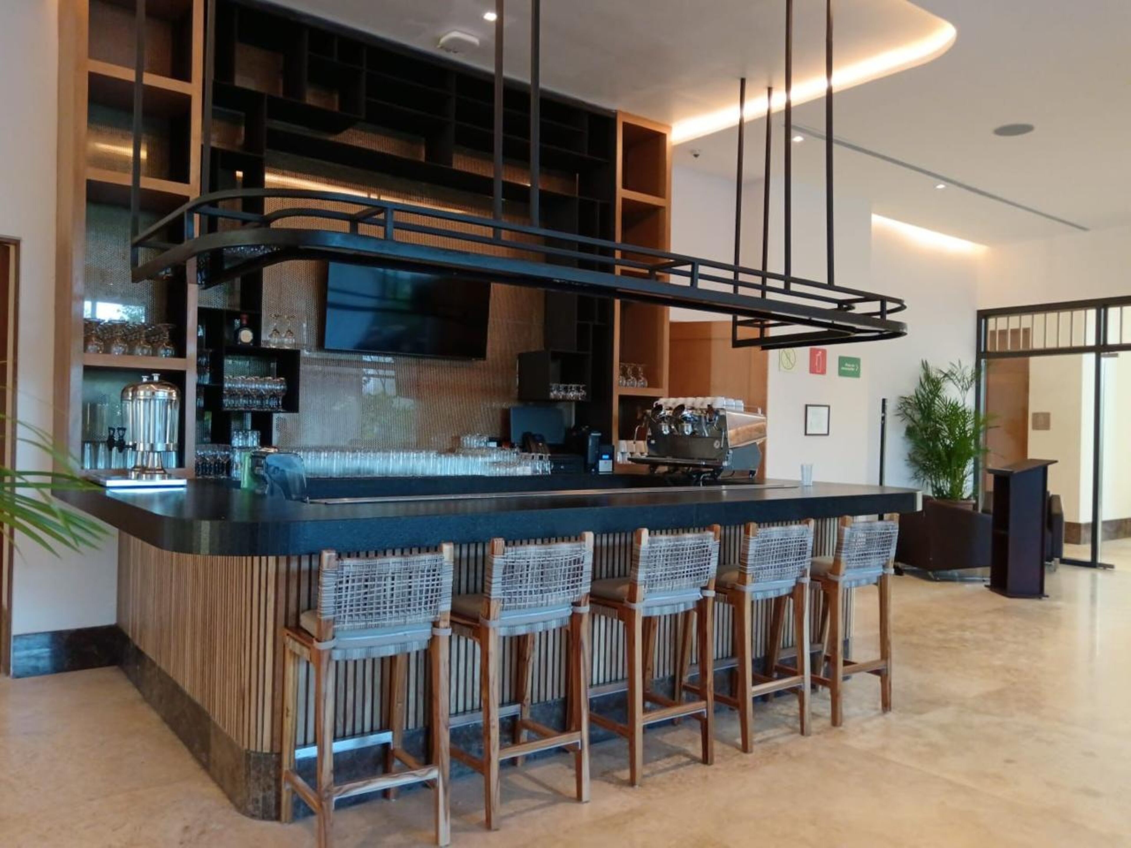 A modern bar area with a central island, bar stools, and a coffee machine.