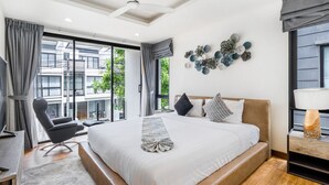 Een moderne hotelkamer met een groot bed, een bureau, een stoel en uitzicht op de stad door grote ramen.