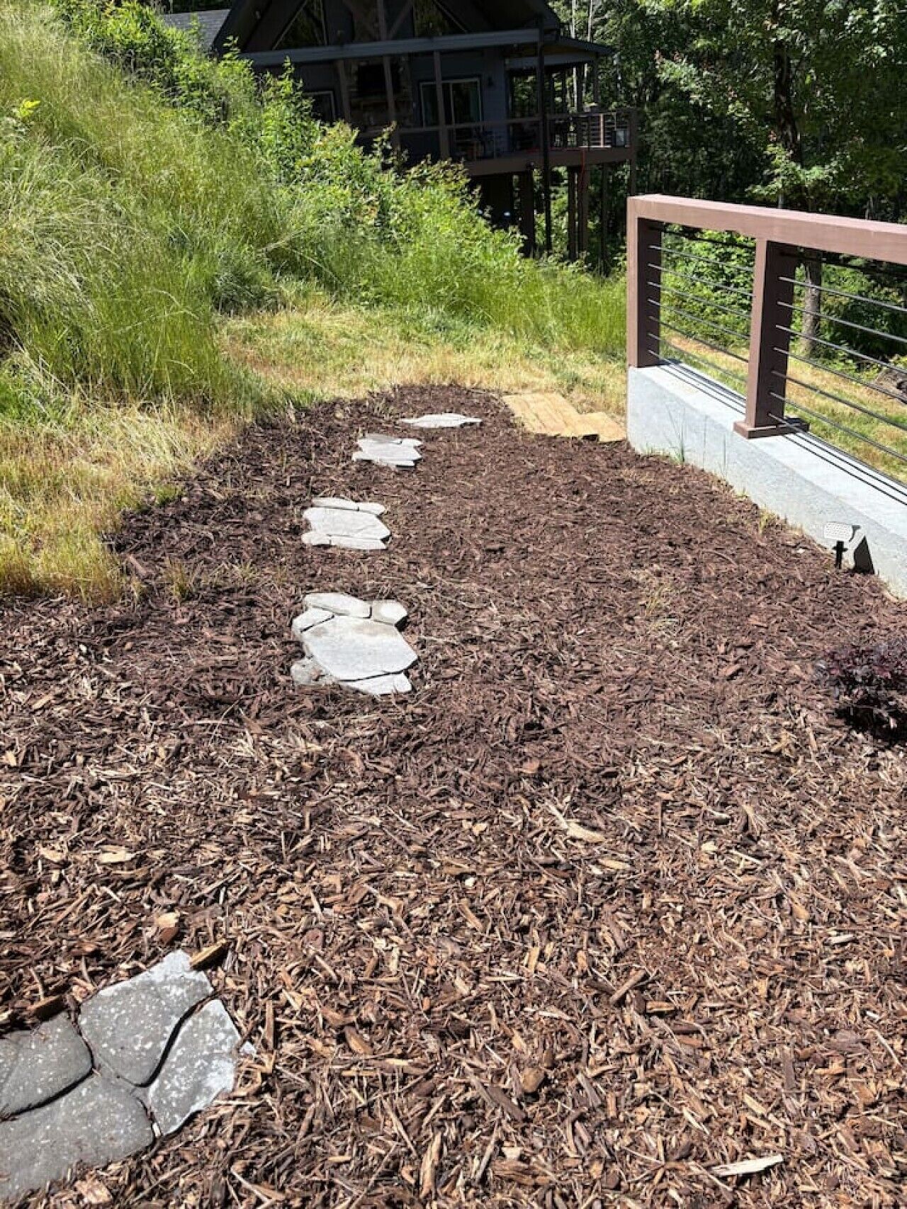 Un sendero con piedras sueltas que lleva a un edificio con terraza.