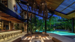 A modern outdoor lounge area with a pool, seating, and ambient lighting. - Villa Baratega (Kerobokan)