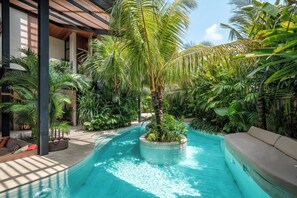An indoor pool with a circular island, surrounded by lush greenery and a modern architectural design. - Villa Baratega (Kerobokan)