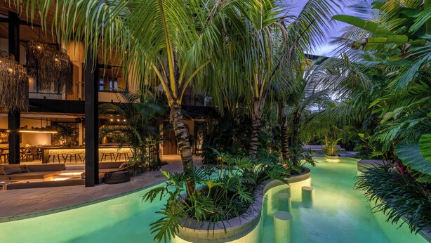 A pool area with tropical plants, a bar, and a seating area. - Villa Baratega (Kerobokan)
