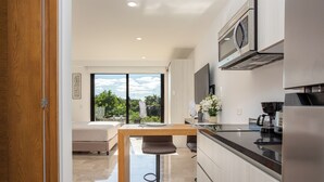 Eine moderne Küche mit einem Holztisch, Barhocker und einem eingebauten Backofen.