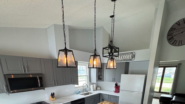 A modern kitchen with a central island, stainless steel appliances, and pendant lighting. - Newly remodeled 3-bedroom ranch with pool table, patio, and grill in Urbandale. (Urbandale)