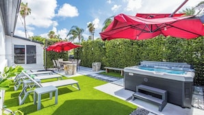Un jardin avec un jacuzzi, du mobilier d’extérieur et un espace patio.