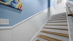 Eine Treppe mit weißer Wandverkleidung und Holzstufen.