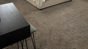 Une chambre à coucher avec un grand lit, une table de chevet, une lampe et une fenêtre avec des stores.
