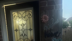 Une porte en bois avec un panneau en verre dépoli et un motif décoratif en métal.