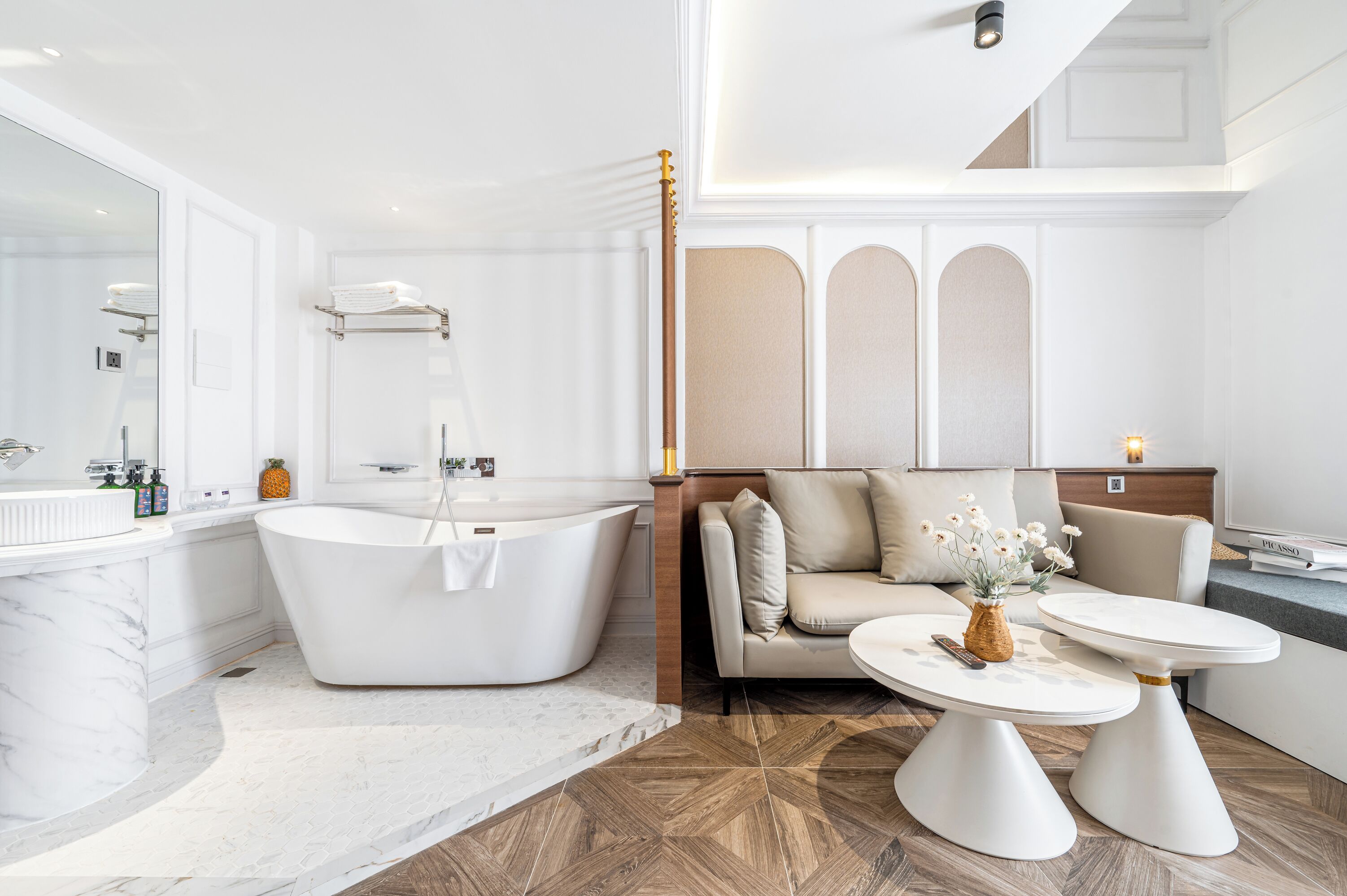 Un baño moderno con una bañera independiente, un espejo grande y un lavamanos de mármol.