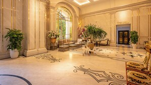A spacious lobby with a high ceiling, marble flooring, and a large potted plant. - Cozrrum Lux - Sonata Imperial (Ho Chi Minh City)