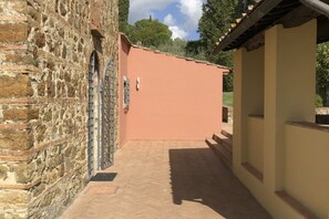 A narrow alleyway with a stone wall on one side and a beige wall on the other. - My Exclusive Italy - Spacious Villa with Private Pool & Garden near Chianti (Impruneta)