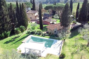 A residential property with a swimming pool, surrounded by greenery and tall trees. - My Exclusive Italy - Spacious Villa with Private Pool & Garden near Chianti (Impruneta)