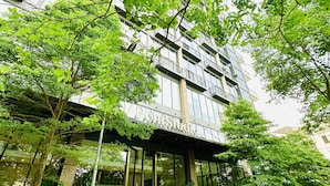 A multi-story building with a modern facade, large windows, and a visible entrance. - PentStudio West Lake by Emily in Town (Hanoi)
