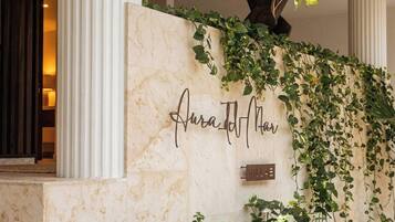 A marble wall with a nameplate reading 'Aurad Hotel' and a sign indicating 'Villa'.