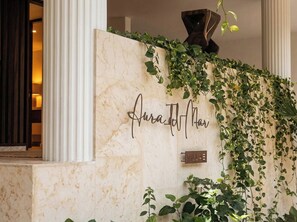 A marble wall with a nameplate reading 'Aurad Hotel' and a sign indicating 'Villa'. - Luxury Penthouse at Aura del Mar (Zihuatanejo)
