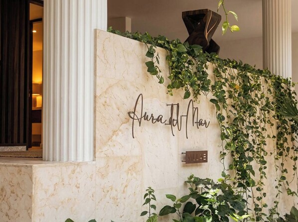 A marble wall with a nameplate reading 'Aurad Hotel' and a sign indicating 'Villa'.