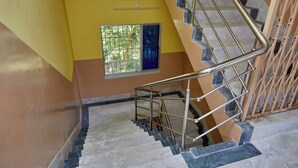A staircase with metal railings and a window with metal bars. - Deb Guest House (Barakpur)