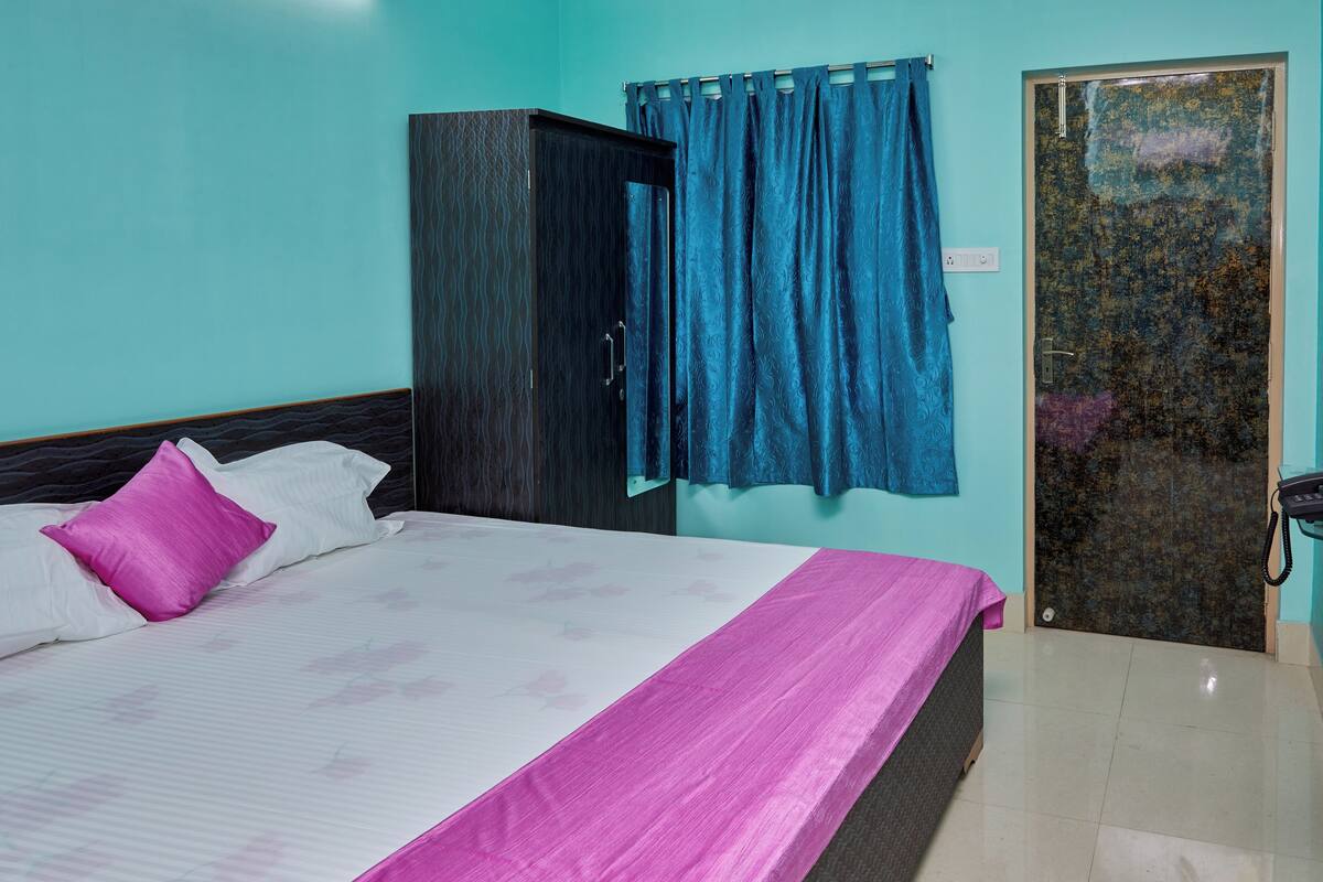 A bedroom with a bed, a wardrobe, and a door.