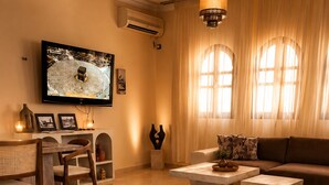 Una sala de estar moderna con un sofá, una mesa de centro, un televisor y una chimenea.