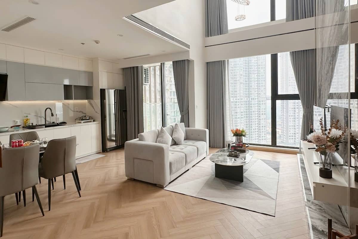 Uma sala de estar moderna com sofá, mesa de centro e área de jantar.