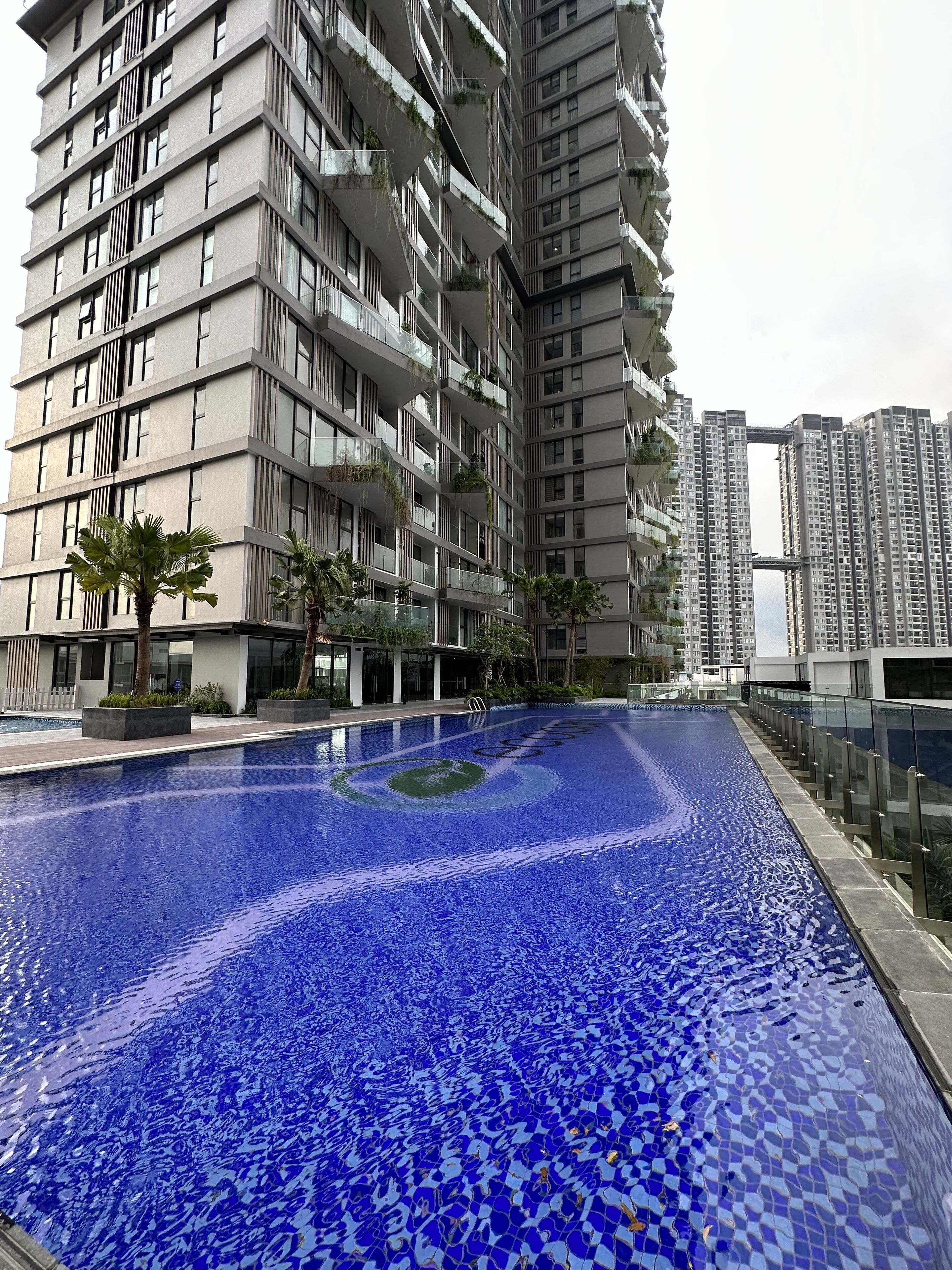 Un moderno edificio de gran altura con una piscina delantera.