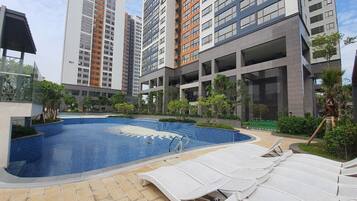 Un moderno edificio residencial con piscina y zona de estar al aire libre.