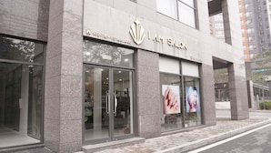 A modern building with a salon named "I AM SALON" on the ground floor.