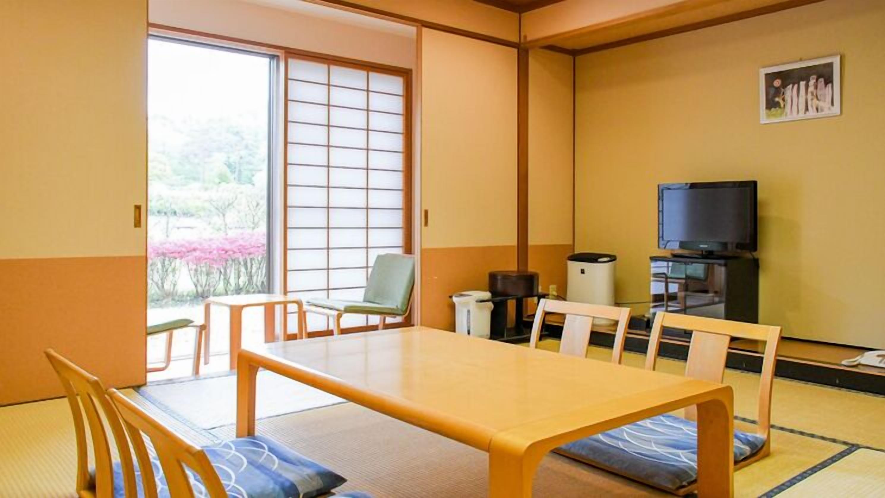 Perinteinen japanilaistyylinen huone, jossa on tatamimatto, matala pöytä ja televisio.
