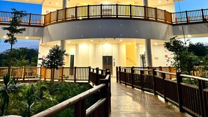 Ein mehrstöckiges Hotel mit einem zentralen Atrium, Holzbalkonen und einem überdachten Gang.