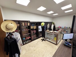 A retail store with shelves of woven baskets, a display of hats, and a counter with various items.