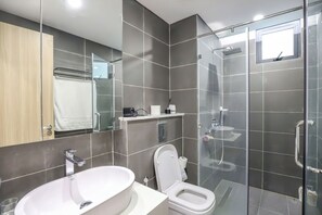 A modern bathroom with a large sink, toilet, and glass-enclosed shower. - The Zei Plaza Luxury Apartments (Hanoi)