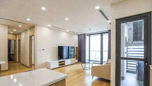 Eine moderne Wohnung mit großem Fernseher, Essbereich und Balkon mit Blick.