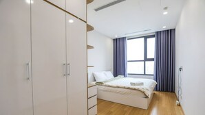 Ein Schlafzimmer mit einem Bett, einem Kleiderschrank und einem Fenster mit Vorhängen.