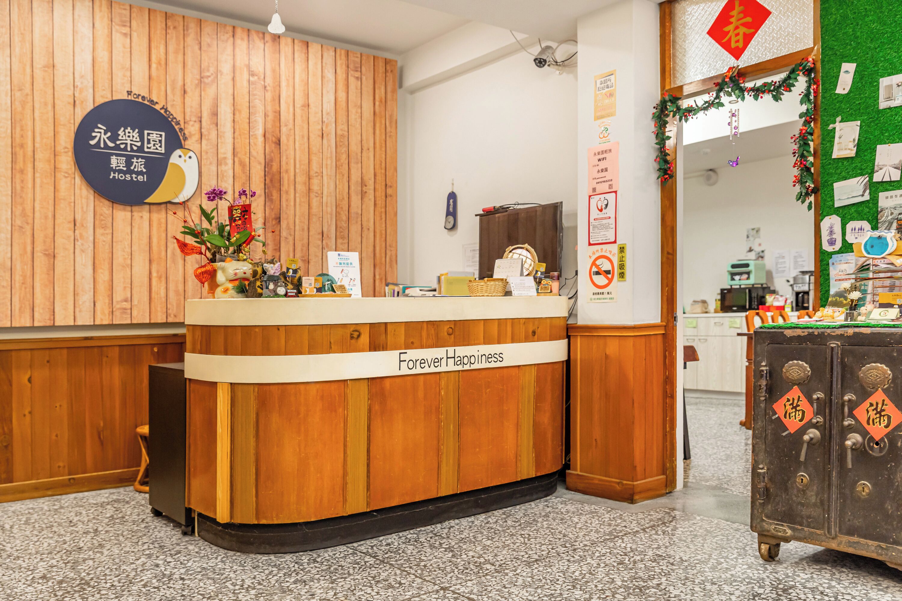 En receptionsdisk i trä med en skylt som visar texten ”Evig lycka” och en skylt med kinesiska tecken.