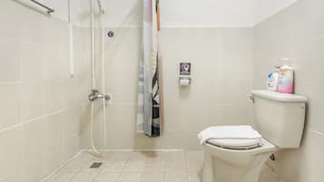 Un baño con ducha, inodoro y barra para toallas.
