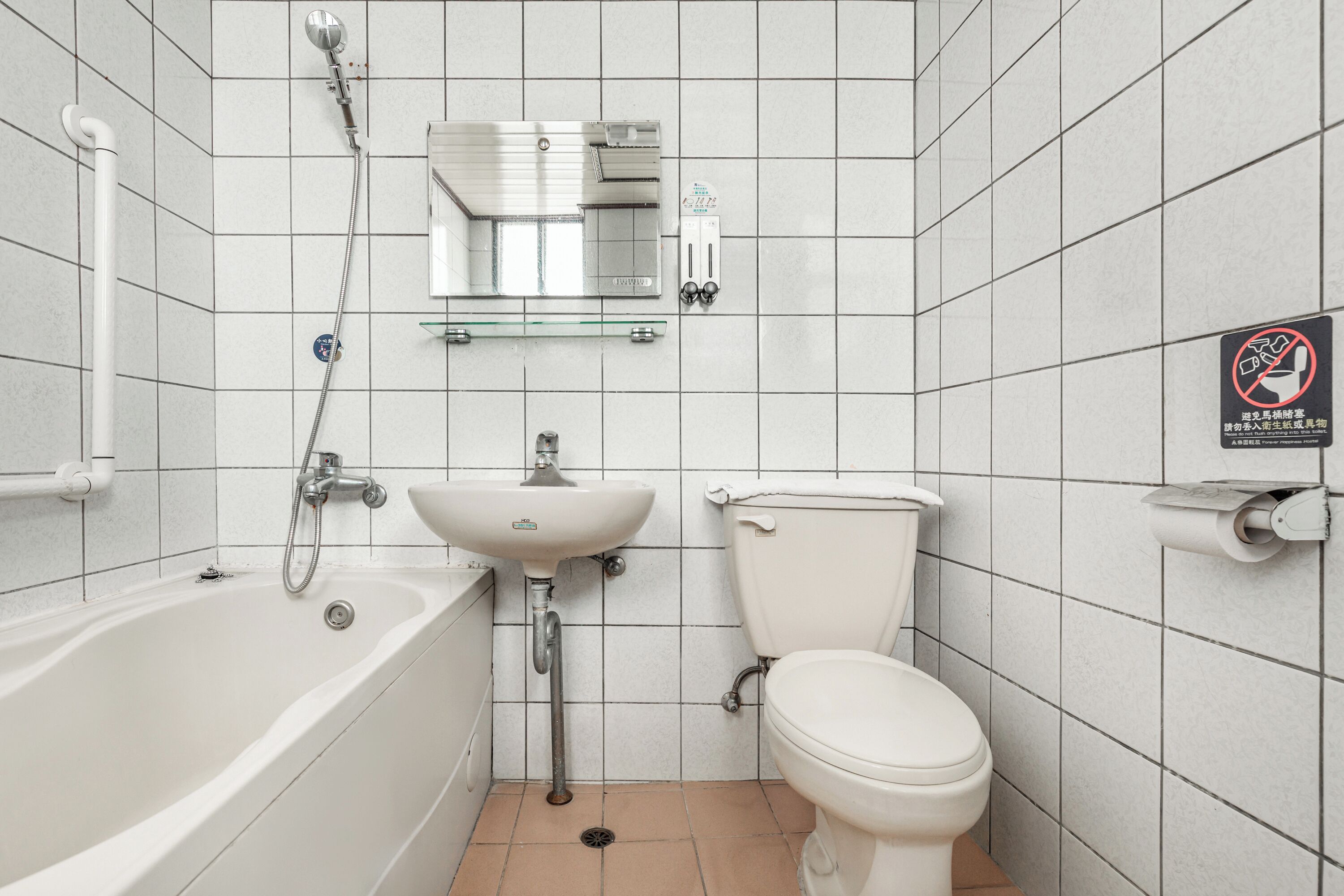 Un baño con bañera, lavamanos, inodoro y un espejo sobre el lavamanos.