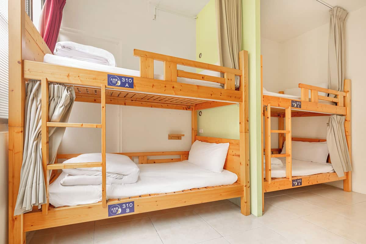 Ein Schlafzimmer mit Etagenbetten, wobei jedes Bett mit einer Zimmernummer gekennzeichnet ist.