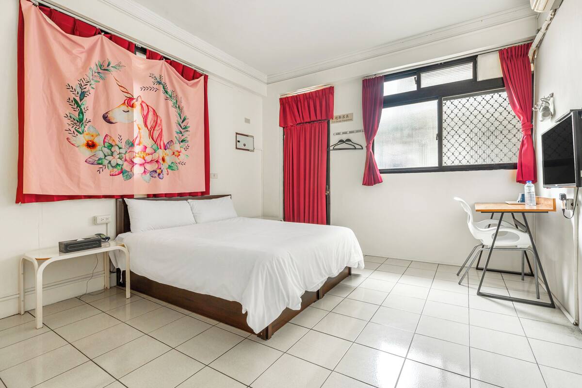 Ein Schlafzimmer mit einem Bett, einem Schreibtisch und einem Stuhl.
