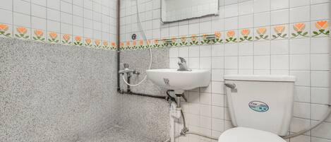 A bathroom with a white sink, toilet, and shower.