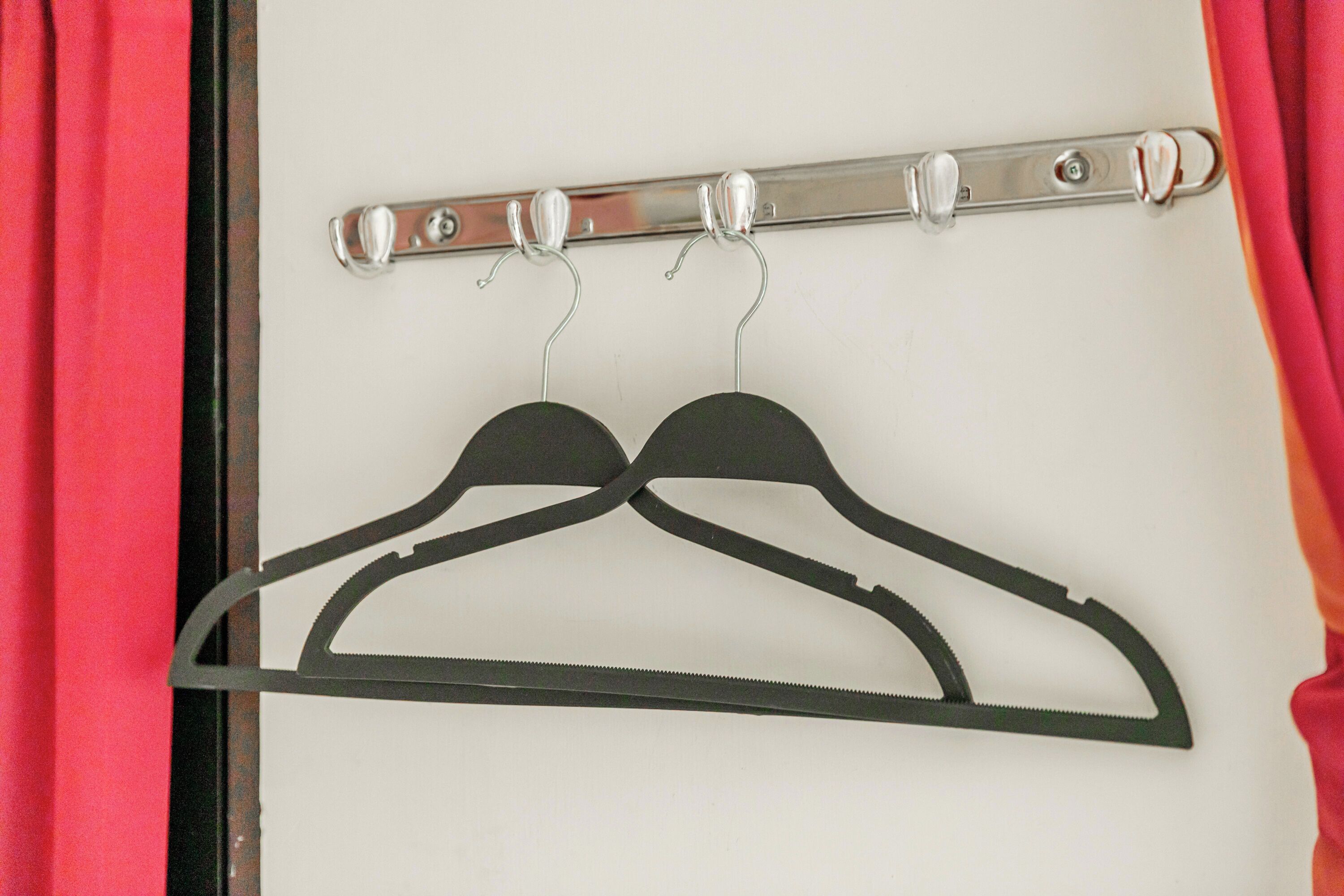A metal rack with two black hangers.
