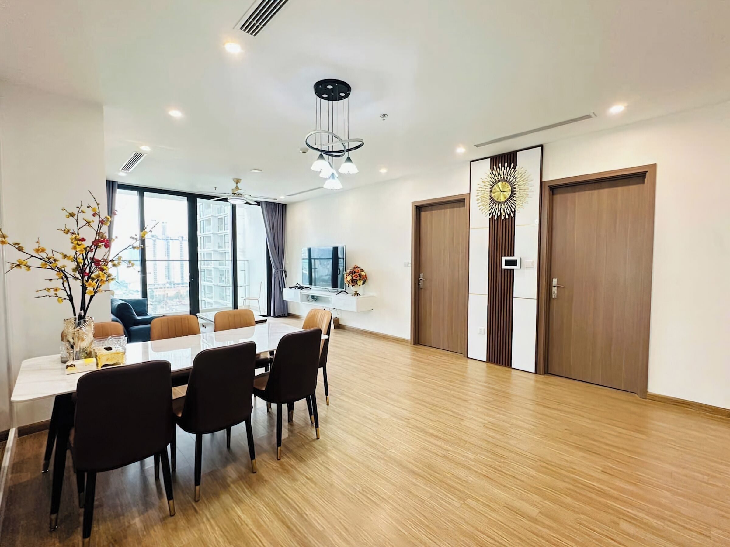 Uma sala de jantar moderna com uma mesa grande, cadeiras e um vaso decorativo.
