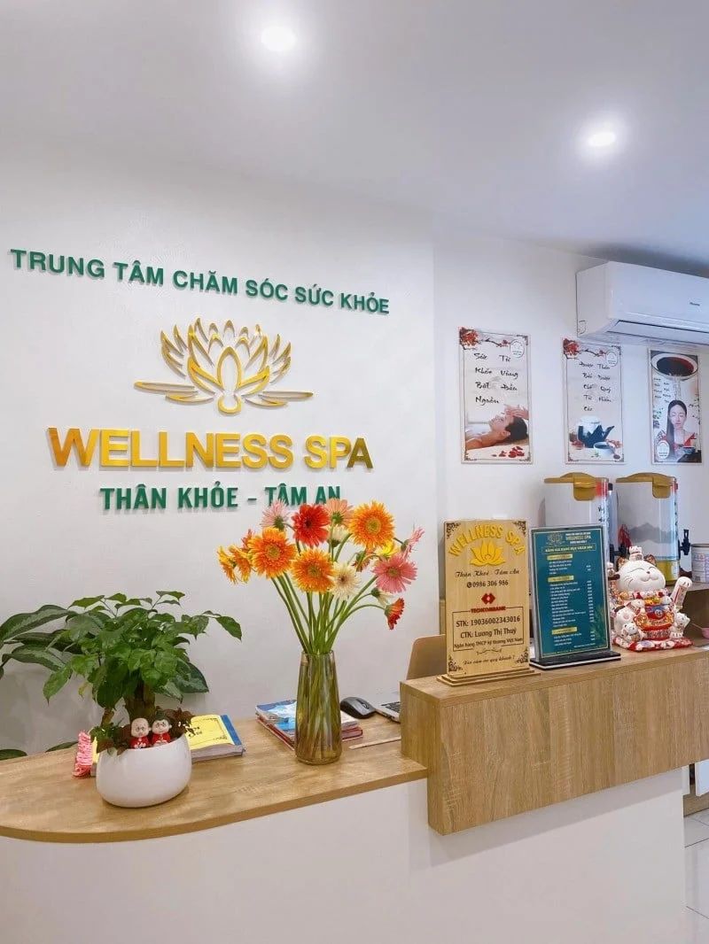 Ein Empfangsbereich mit einem Schild für 'Wellness Spa' und einer Blumenvase.