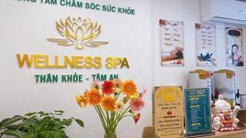 Ein Empfangsbereich mit einem Schild für 'Wellness Spa' und einer Blumenvase.