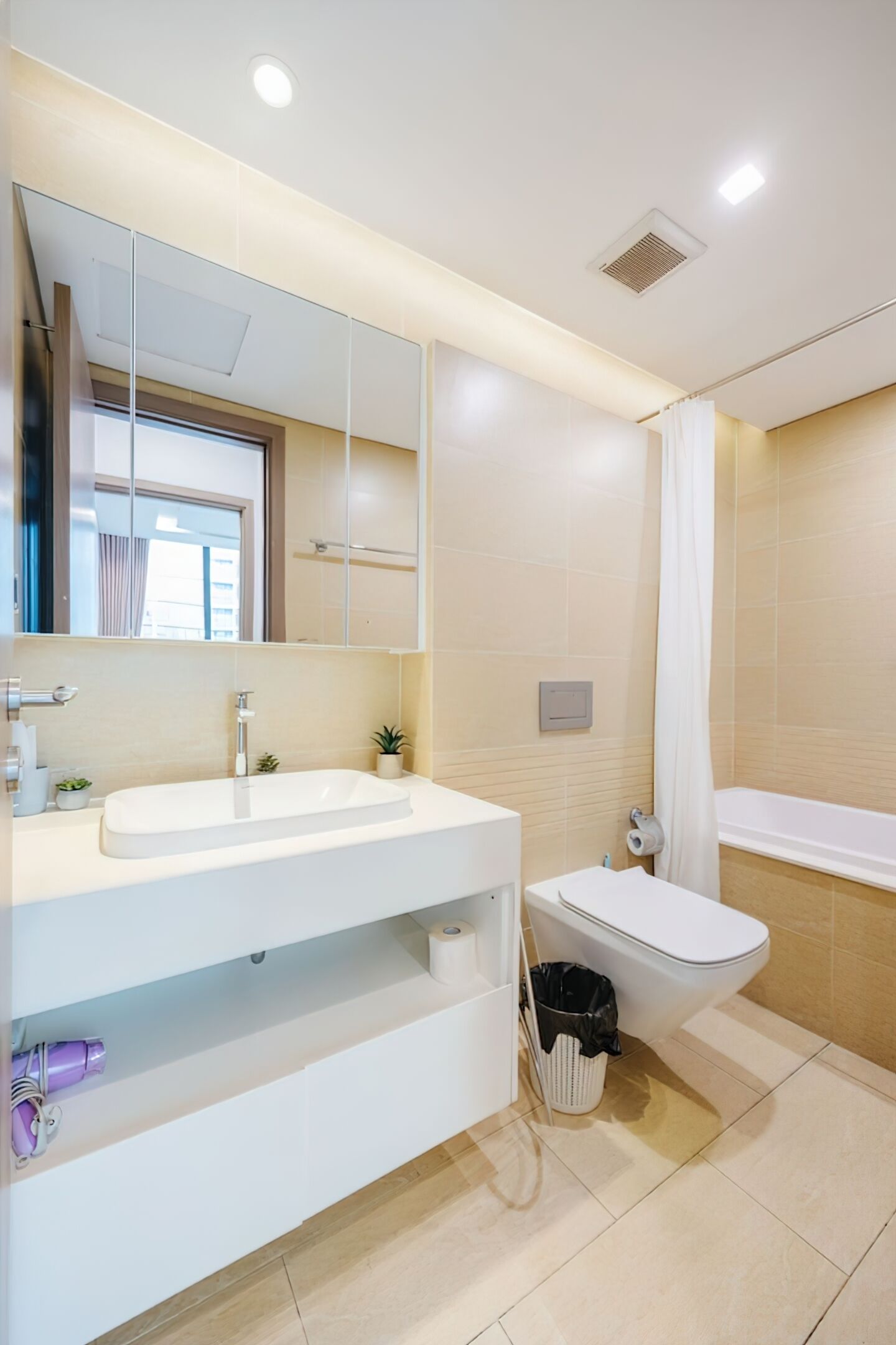 Une salle de bain moderne avec un lavabo blanc, un miroir et une baignoire.