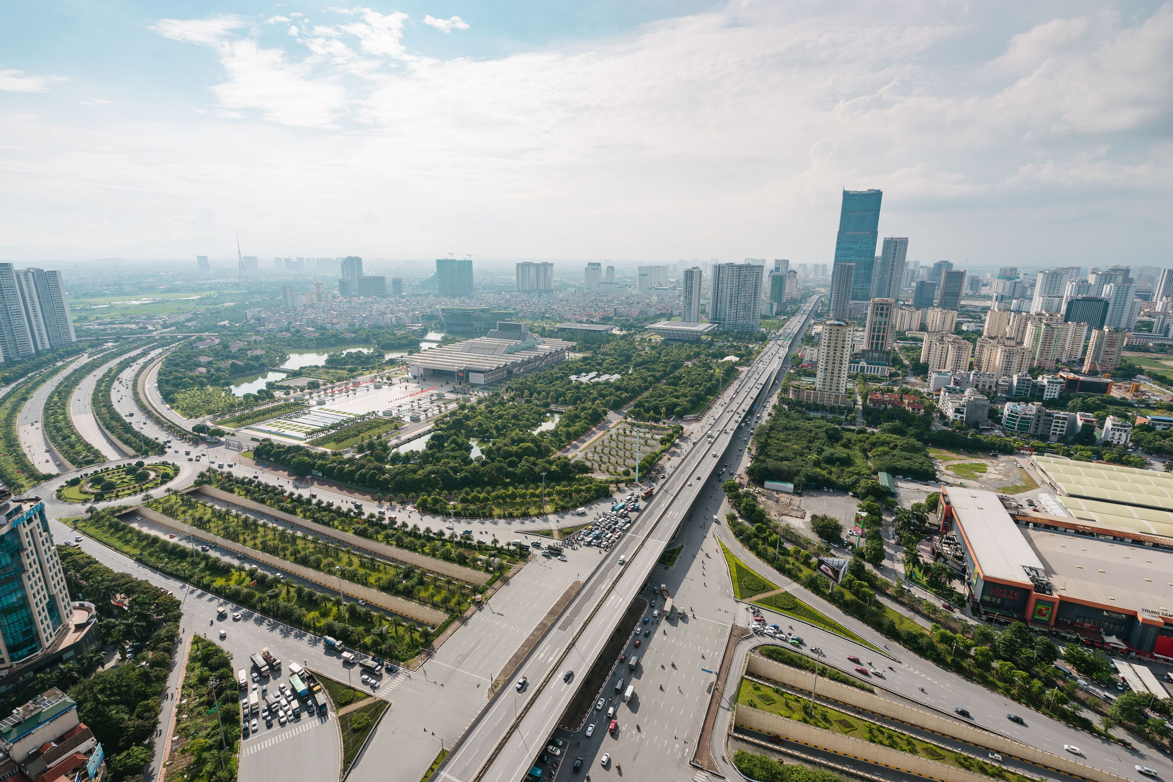 A cityscape with a prominent highway, high-rise buildings, and a large stadium.